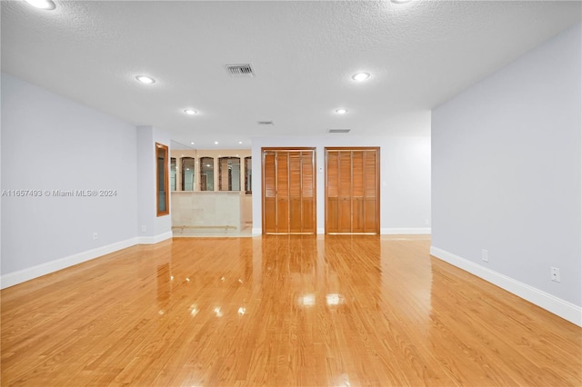 spare room with a textured ceiling and hardwood / wood-style flooring