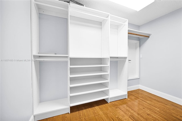 walk in closet with wood finished floors