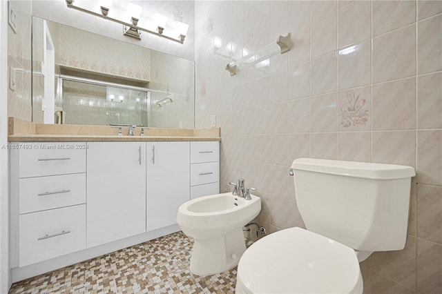 bathroom with a shower stall, vanity, tile walls, toilet, and a bidet