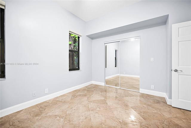 unfurnished bedroom with a closet and a textured ceiling