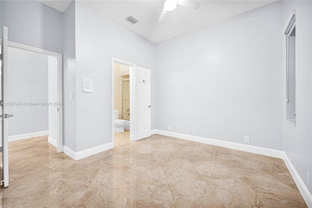 unfurnished bedroom featuring ceiling fan, connected bathroom, and a textured ceiling