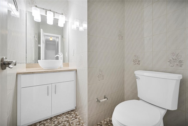 bathroom featuring vanity, toilet, tile walls, and tile patterned flooring