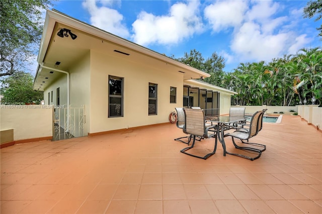 view of patio with fence, outdoor dining space, and a fenced in pool