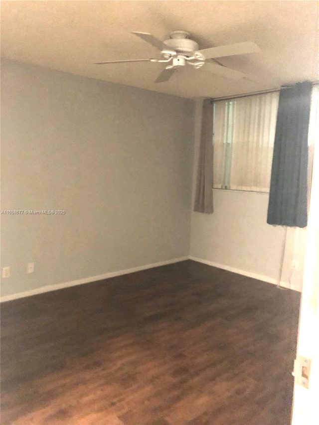 empty room with dark hardwood / wood-style floors and ceiling fan