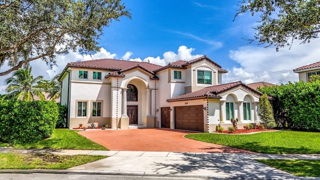 mediterranean / spanish-style house featuring a front yard and a garage