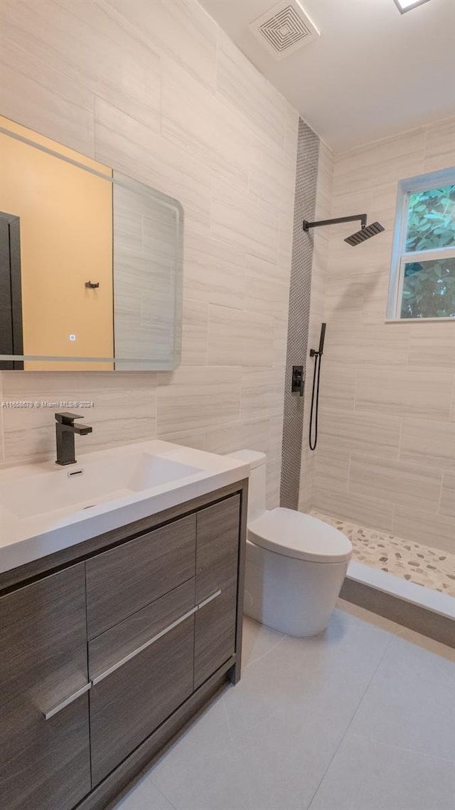 bathroom featuring tiled shower, vanity, toilet, and tile patterned floors