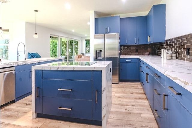 kitchen featuring pendant lighting, light hardwood / wood-style flooring, blue cabinetry, a center island, and stainless steel appliances