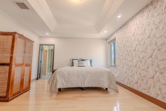 bedroom featuring a tray ceiling and hardwood / wood-style flooring