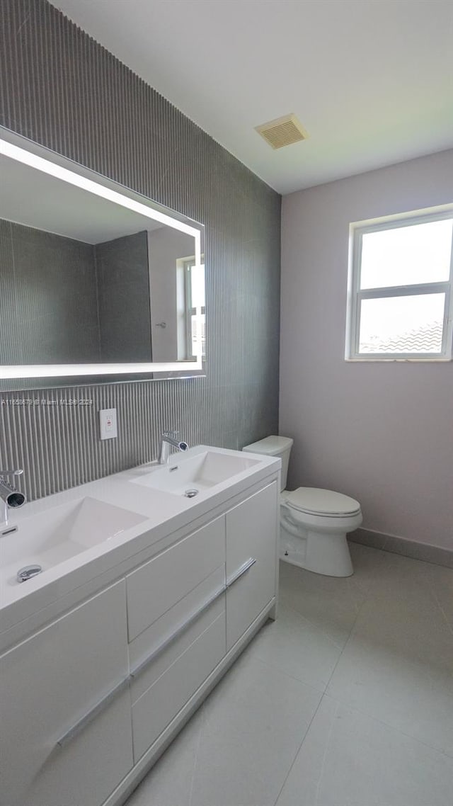 bathroom with vanity, toilet, and tile patterned flooring