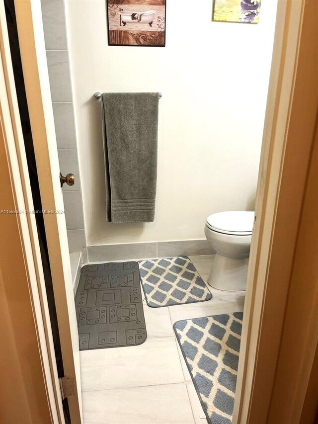 bathroom featuring tile patterned flooring and toilet