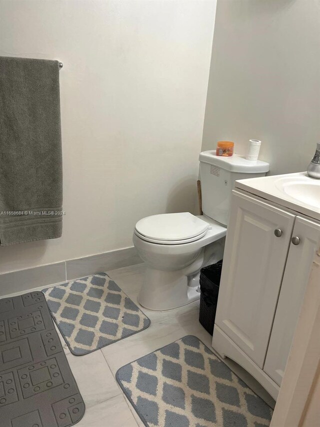 bathroom featuring vanity, toilet, and tile patterned flooring