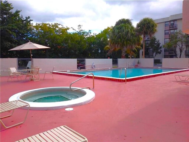 view of swimming pool featuring a community hot tub and a patio