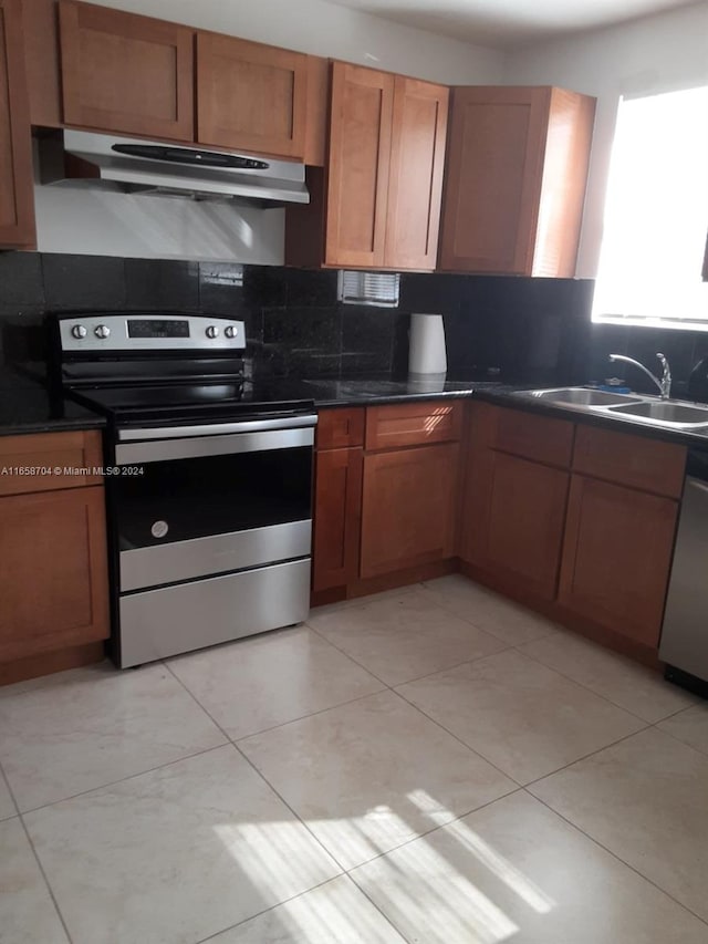 kitchen with light tile patterned floors, stainless steel appliances, sink, and decorative backsplash