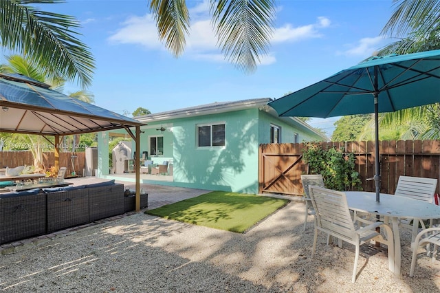 rear view of property with an outdoor hangout area, fence, outdoor dining area, a patio area, and stucco siding