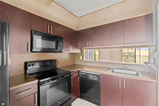 kitchen featuring black appliances, plenty of natural light, light tile patterned floors, and sink