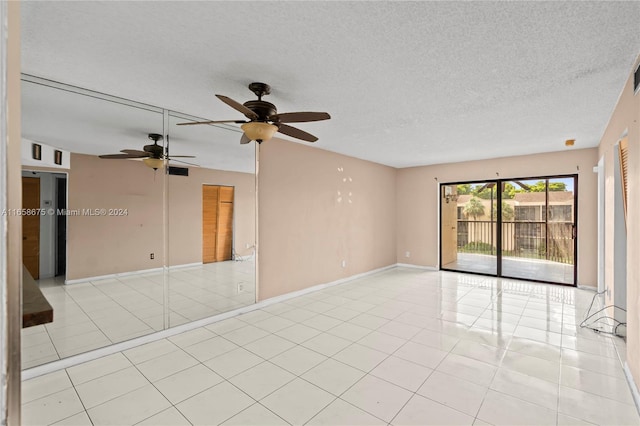 tiled empty room with a textured ceiling and ceiling fan