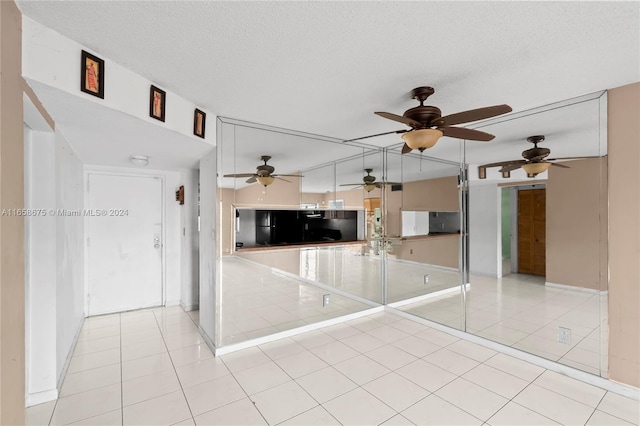 kitchen featuring a textured ceiling, light tile patterned floors, and ceiling fan