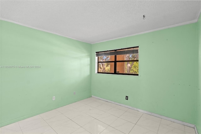 empty room with crown molding, a textured ceiling, and light tile patterned flooring