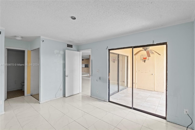 unfurnished bedroom featuring ensuite bath and a textured ceiling