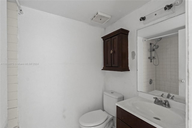 bathroom featuring vanity, toilet, and a tile shower