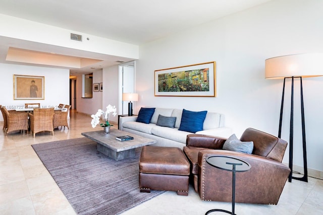 tiled living room featuring a raised ceiling