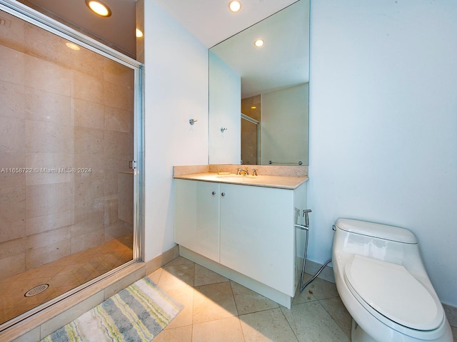 bathroom with vanity, toilet, tile patterned floors, and a shower with door