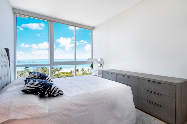 bedroom with expansive windows and a water view