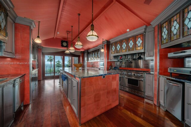 kitchen featuring pendant lighting, a center island, dark hardwood / wood-style floors, vaulted ceiling, and appliances with stainless steel finishes