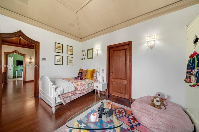 bedroom with dark wood-type flooring and crown molding