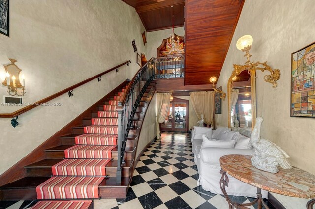 stairs featuring wood ceiling, high vaulted ceiling, and an inviting chandelier