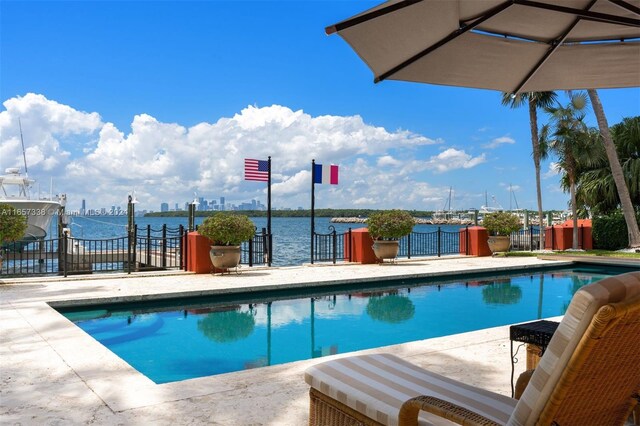 view of swimming pool with a water view and a patio