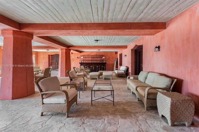 living room with wood ceiling, ornate columns, and beam ceiling