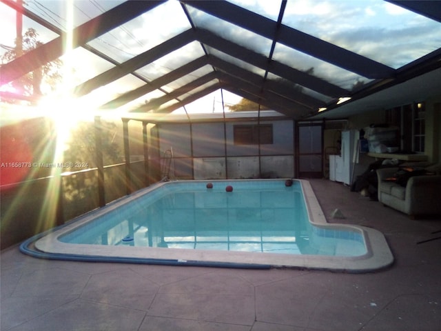 view of swimming pool with a patio and glass enclosure