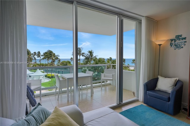 tiled living room with a water view and a wall of windows