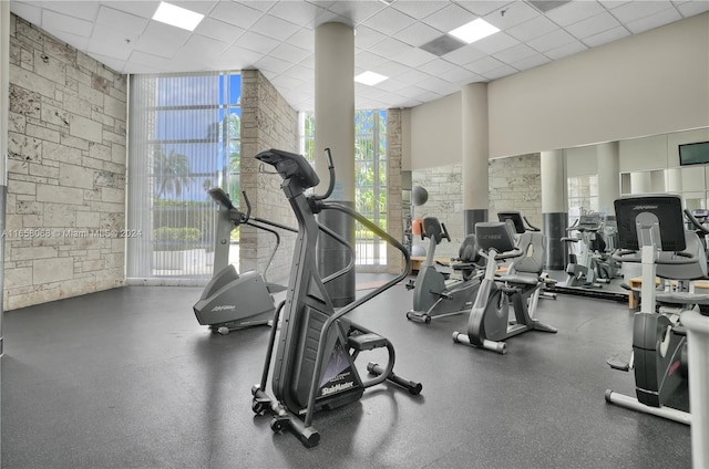 gym with expansive windows and a drop ceiling