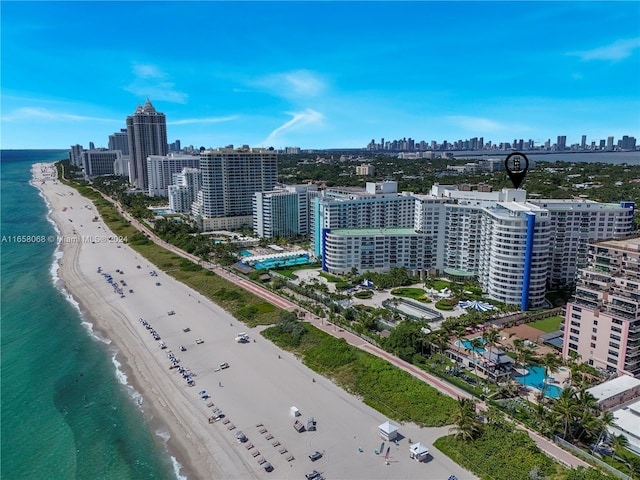 drone / aerial view featuring a water view and a view of the beach