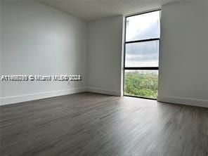 13499 Biscayne Blvd Unit 801, North Miami, FL 33181 - empty room with wood finished floors, baseboards, and floor to ceiling windows