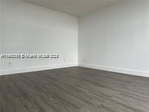 unfurnished room with dark hardwood / wood-style flooring