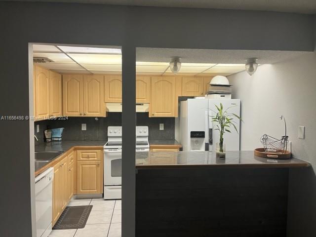 10411 SW 108th Ave Unit 153, Miami, FL 33176 - kitchen with white appliances, extractor fan, light brown cabinets, light tile patterned floors, and a sink