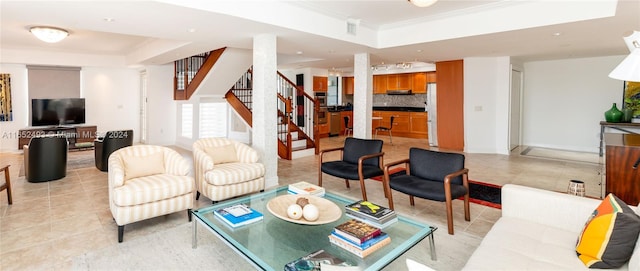 tiled living room featuring a tray ceiling and ornamental molding