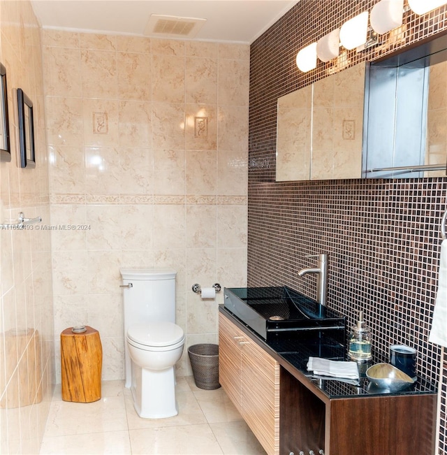 bathroom with tile patterned flooring, tile walls, toilet, and decorative backsplash