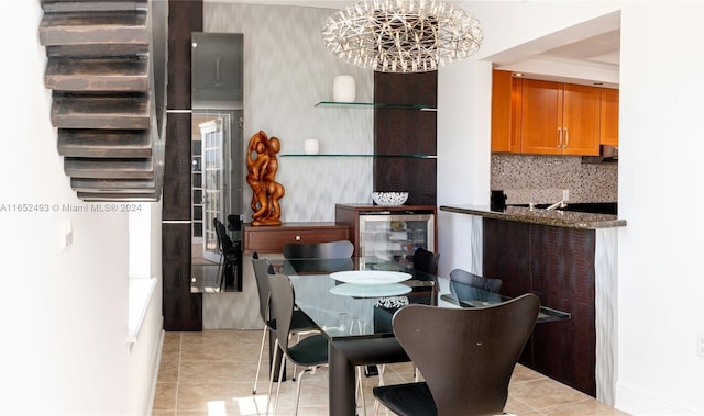 tiled dining space featuring beverage cooler and a notable chandelier