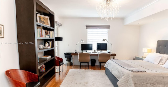 bedroom with light wood-type flooring, crown molding, and a chandelier