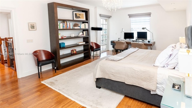 bedroom with wood-type flooring and a notable chandelier