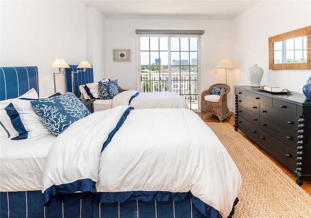 bedroom featuring crown molding, access to outside, and light hardwood / wood-style floors