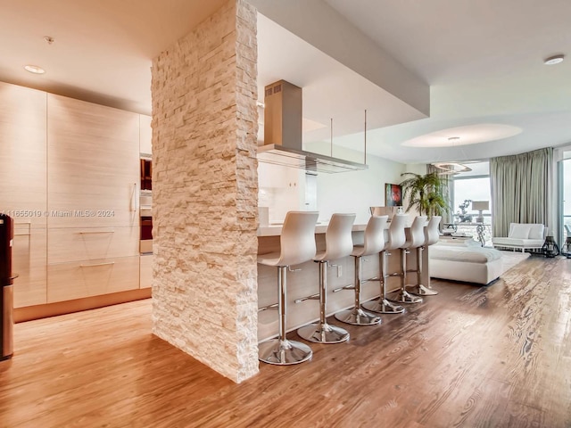 kitchen with hardwood / wood-style floors and a kitchen breakfast bar