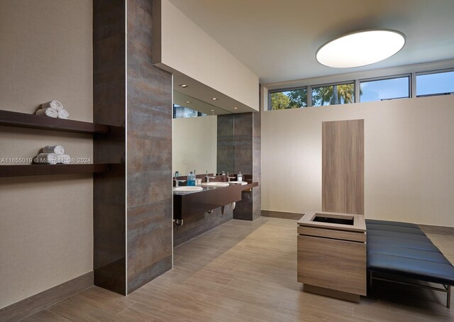 bathroom featuring a towering ceiling, hardwood / wood-style flooring, and double sink