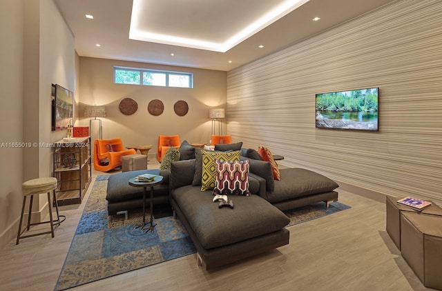 living room with a tray ceiling and light hardwood / wood-style floors