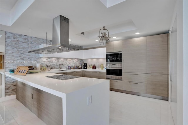 kitchen with pendant lighting, light tile patterned flooring, island range hood, black appliances, and an inviting chandelier