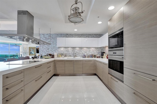 kitchen with light tile patterned flooring, sink, island exhaust hood, appliances with stainless steel finishes, and light brown cabinetry